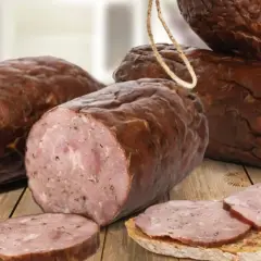 Kiełbasa żywiecka, wędzona, z widocznym przekrojem i plastrami na chlebie.