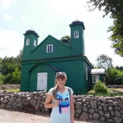 Kobieta na tle zielonego meczetu, element szlaku tatarskiego.