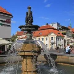 Fontanna na Rynku Kościuszki w Białymstoku, otoczona kawiarniami i zabytkową architekturą.