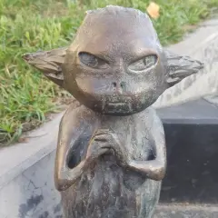 Brązowy bebok co to? Mały stworek z wielkimi uszami i zamyśloną miną, siedzi na trawie.