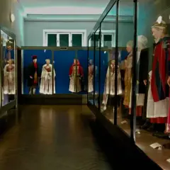 Wystawa muzealna z manekinami ubranymi w tradycyjne polskie stroje ludowe.