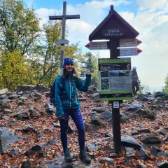 Uśmiechnięta turystka na szczycie Łysicy, 614 m n.p.m. Jesienne liście i kamienie wokół.