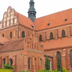 Imponująca ceglana katedra w Pelplinie z charakterystycznymi dachami i wieżą.
