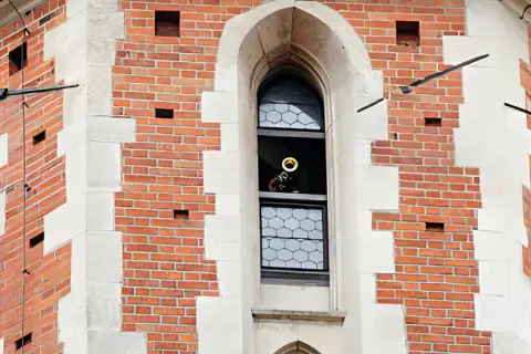 Trębacz gra hejnał mariacki z okna wieży.