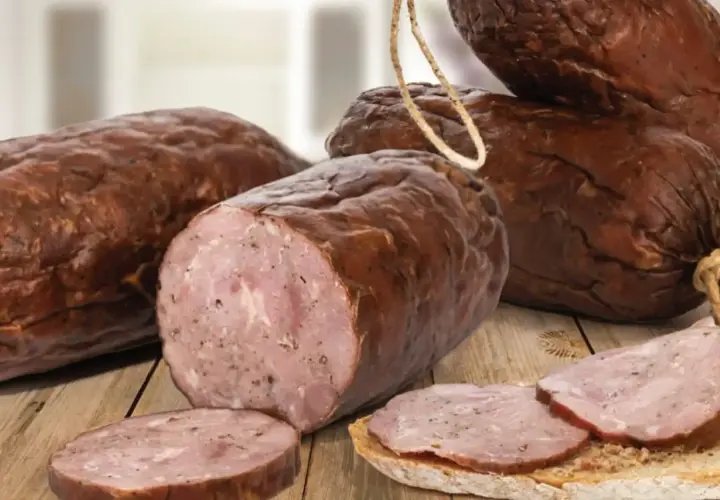 Kiełbasa żywiecka, wędzona, z widocznym przekrojem i plastrami na chlebie.