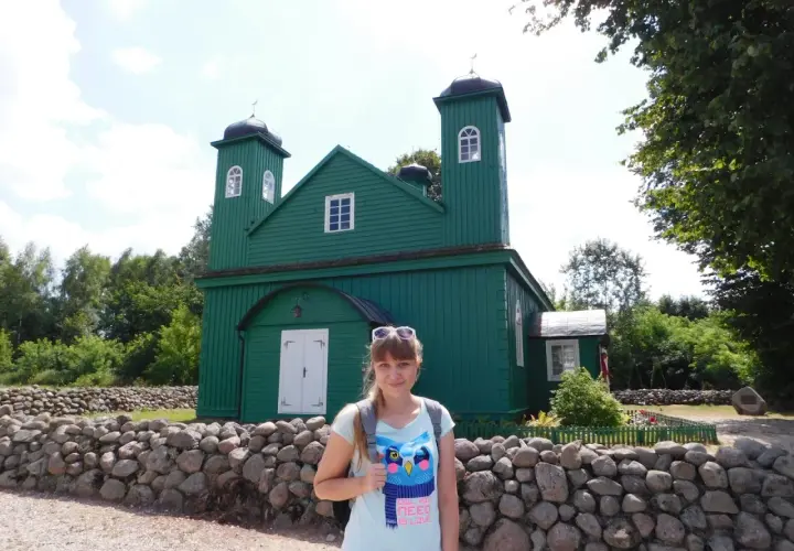 Kobieta na tle zielonego meczetu, element szlaku tatarskiego.