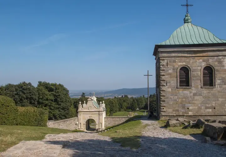 Kamienna wieża i zabytkowa brama na święty krzyż trasie. Widok na dolinę i lasy.