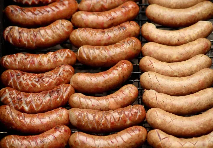 Grillowane kiełbaski lisieckie, rumiane i apetyczne, leżą na ruszcie, gotowe do podania.