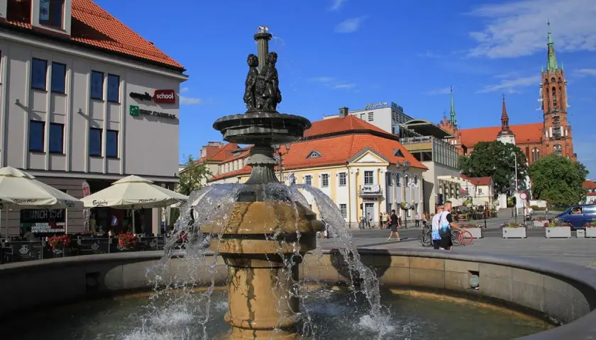 Fontanna na Rynku Kościuszki w Białymstoku, otoczona kawiarniami i zabytkową architekturą.