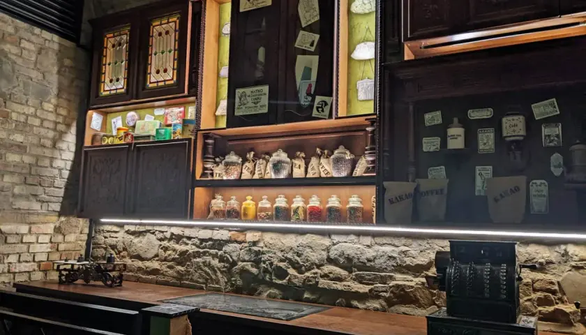 Stare półki z herbatą, kawą i słodyczami, jak w sklepie na Rzeszów Rynek. W tle zabytkowa kasa.