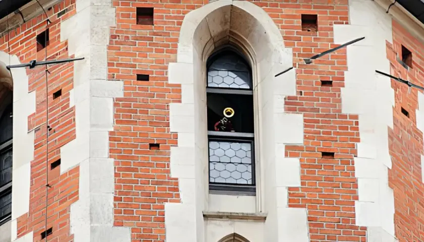 Trębacz gra hejnał mariacki z okna wieży.