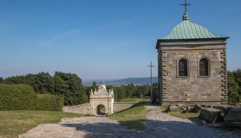 Kamienna wieża i zabytkowa brama na święty krzyż trasie. Widok na dolinę i lasy.