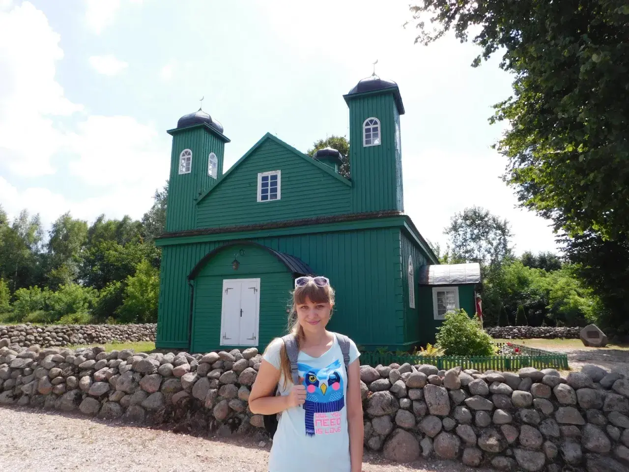 Kobieta na tle zielonego meczetu, element szlaku tatarskiego.