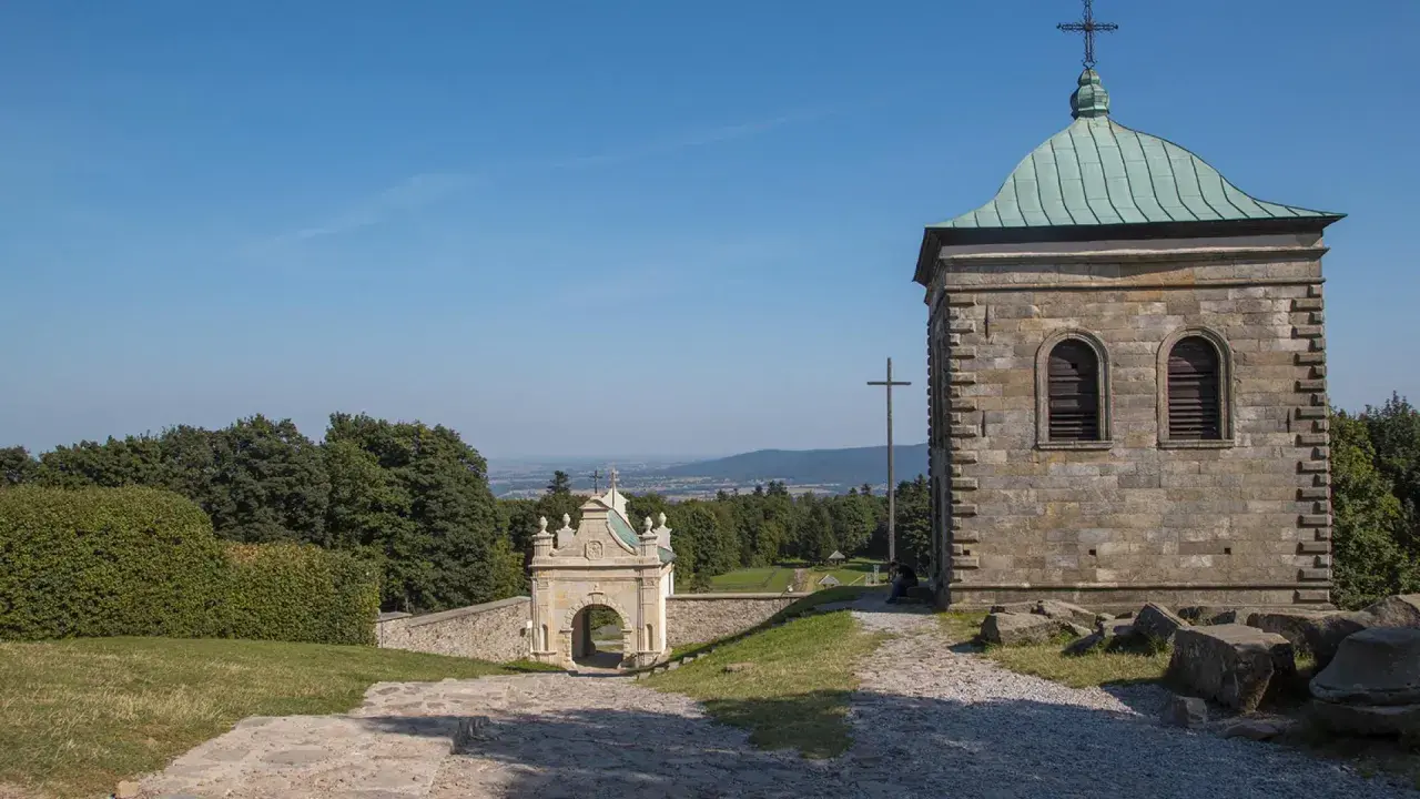 Kamienna wieża i zabytkowa brama na święty krzyż trasie. Widok na dolinę i lasy.