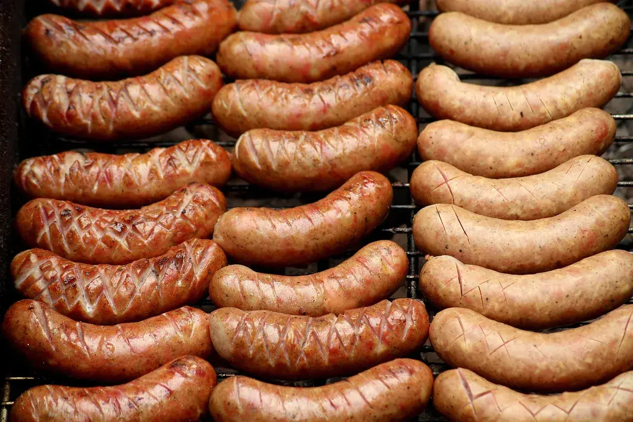 Grillowane kiełbaski lisieckie, rumiane i apetyczne, leżą na ruszcie, gotowe do podania.