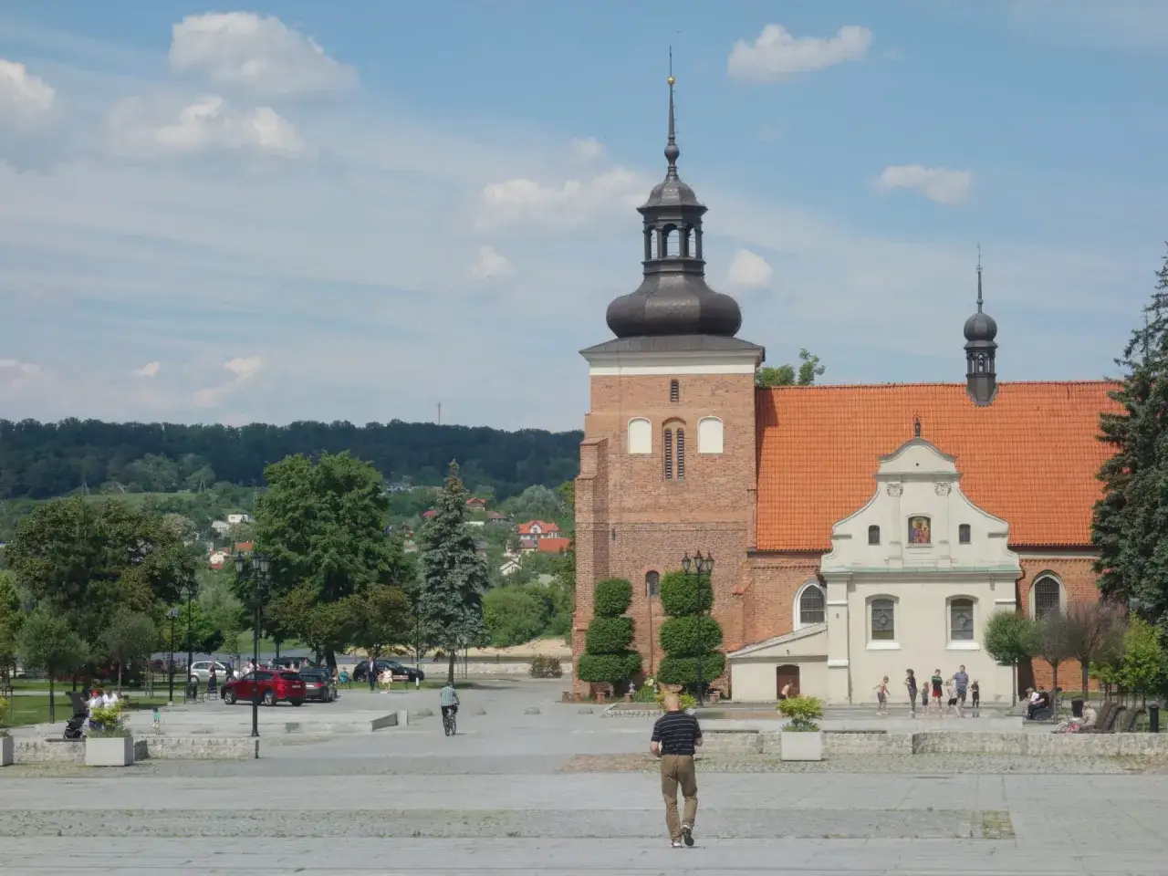 Włocławek atrakcje na weekend: plac z katedrą, park i ludzie spacerujący w słoneczny dzień.