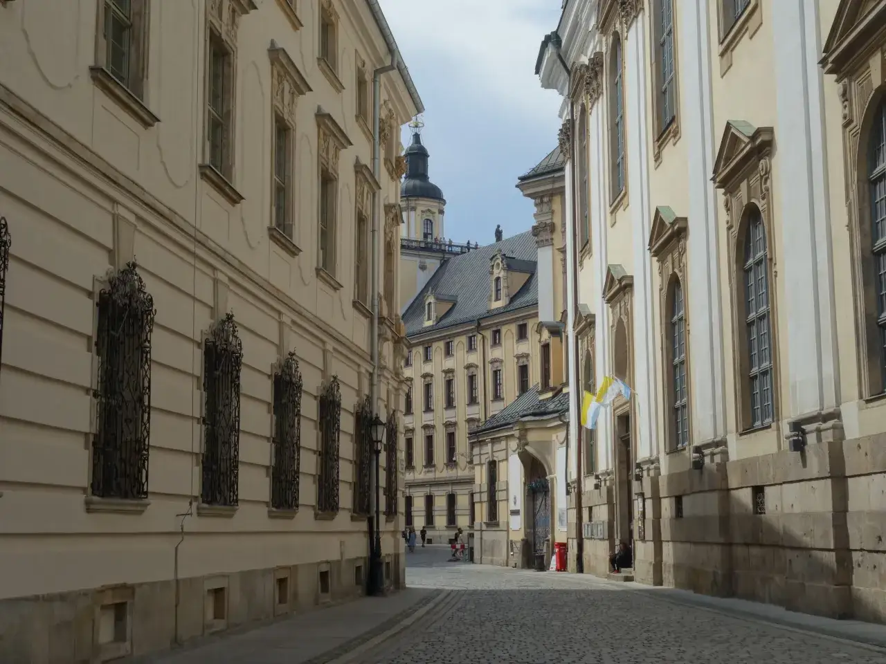 Ulica na starym rynku we Wrocławiu, z zabytkowymi kamienicami i brukowaną nawierzchnią.