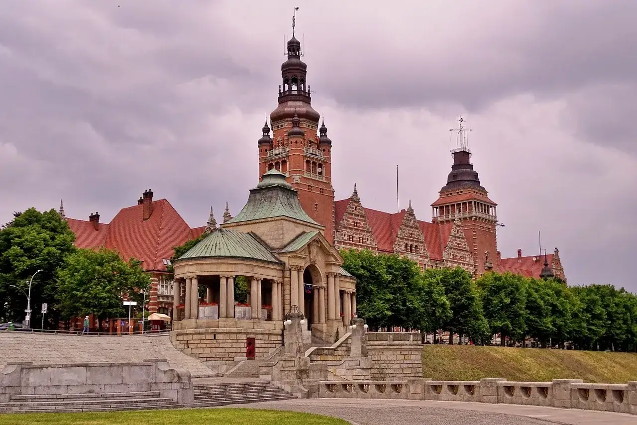 Imponujący budynek z wieżami i zielonym pawilonem, część zabytkowego Szczecina.